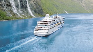 AIDAaura fährt durch die atemberaubende Landschaft des Geiranger Fjords